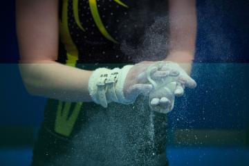 Gymnast applies chalk to hands